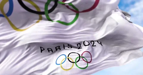 Paris 2024 flag waving in the wind with the Olympic flag in the foreground Stock Footage 157679418