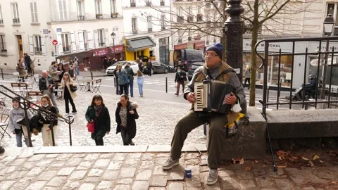 Paris busker senior man sit plays harmonic music on public square place in Montm Stock Footage 165488743