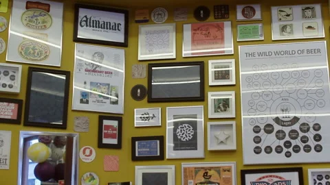Paris Craft Beer Bar Decor Wall Panning Shot of Framed Art and Beer Logos Stock Footage 346286015