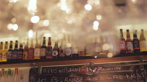 Paris Craft Beer Bar Rack Focus from Blurred Glassware to Bottle Shelf Stock Footage 346393969