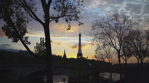 Paris Eiffel Tower between trees and river at sunset Видео 331126078