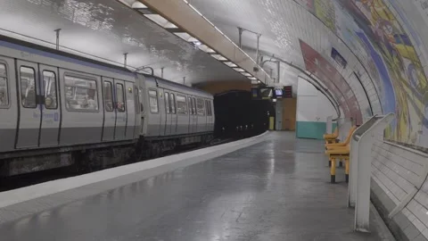 Paris metro train leaving underground station with colorful tiled mural and Stock Footage 305642357