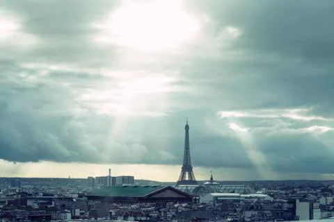 Paris skyline with rooftops and the Eiffel tower on a cloudy day with sun rays Foto stock