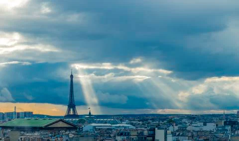 Paris skyline with rooftops and the Eiffel tower on a cloudy day with sun rays Foto stock
