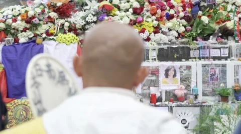 Paris terror attacks - Buddhist monk looking at shrine Stock Footage 57245784
