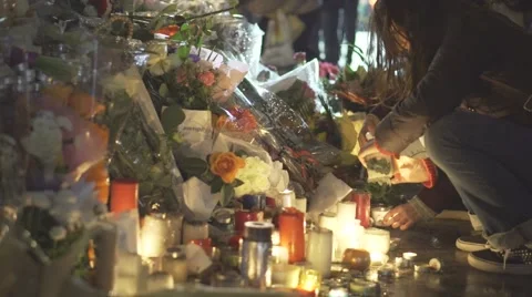 Paris terror attacks - Shrine, peole lighting candles Stock Footage 57339330