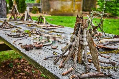 Park background of picnic table covered in small stick teepee piles