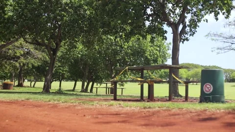 Park bench closed and blocked with yellow caution tape from COVID 19 lockdown. Stock Footage 130416713