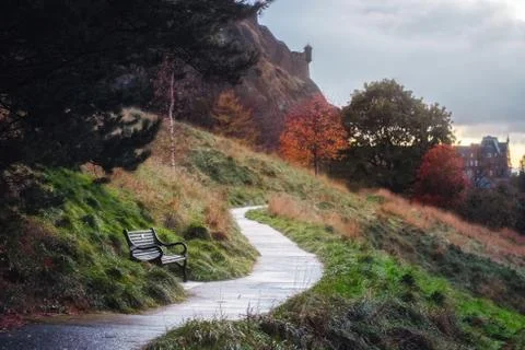 Park bench, footpath on the background of an old castle Stock Photos