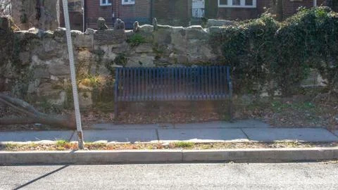 A Park Bench in Front of a Cobblestone Wall Stock Photos