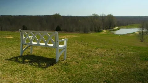 Park bench overlooking a lake Stock Footage 22346647