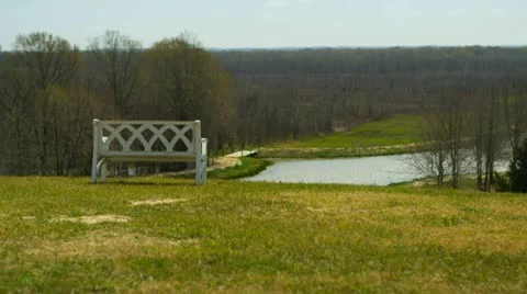 Park bench overlooking a lake Stock Footage 22346899
