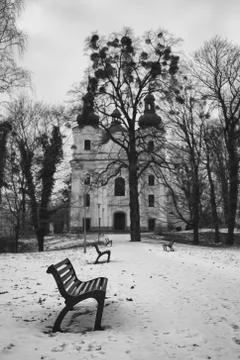 Park, bench, pathway, bare tree and church in the winter Stock Photos