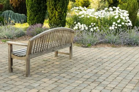 Park bench on paved walk Stock Photos