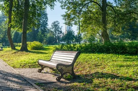 Park bench is sitting on a brick path Photos