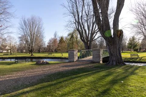 Park with a bridge over a stream in spring. Stewart Park In Perth, Ontario, C Stock Photos