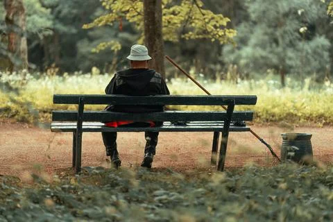 Park cleaner sitting on a bench and resting Stock Photos