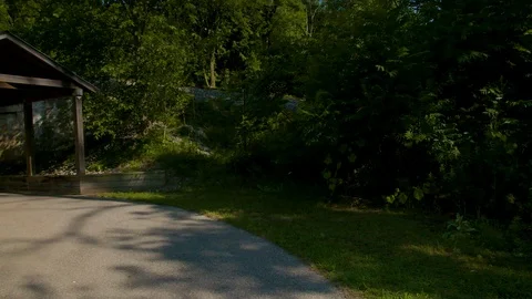 Park covered walking path under railroad man walks by Stock Footage 128662893