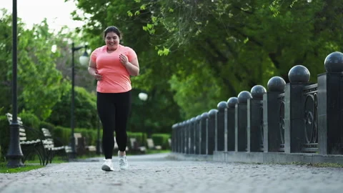 Park jogging weight loss overweight woman running Stock Footage