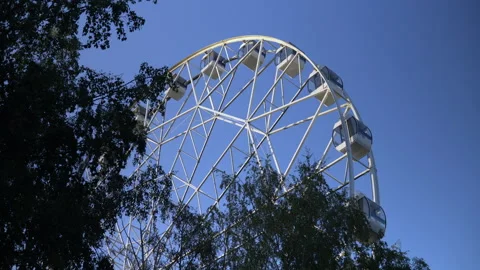 In the park, a large Ferris wheel is spinning slowly. High-altitude view wheel Video stock 139980973