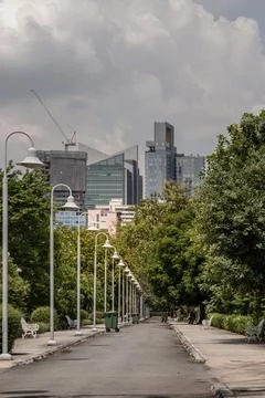 A park path with a concrete border. Row of lantern light lamps, Cast iron b.. Stock Photos