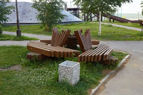 A park with a pathway lined with trees, benches, and grassy areas. 스톡 사진