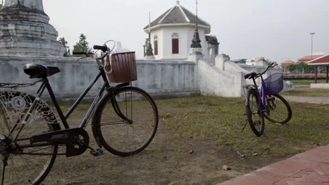 Park two bicycles at the riverside temple Stock Footage 275592398