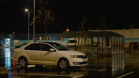 Parked car in empty lot during storm with lightning and dark clouds Stock Footage 318821367
