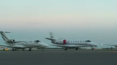Parked jets in foreground, plane takes off Stockbeeldmateriaal 112591