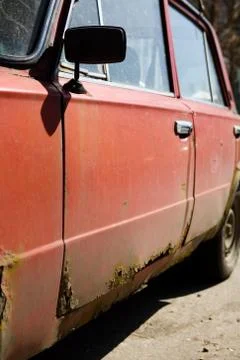 Parked old rusty red Soviet car. Stock Photos