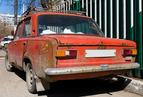 Parked old rusty red Soviet car. Stock Photos