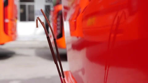 Parked red buses with incense burning on their hoods show regional beliefs where Video stock 313485844