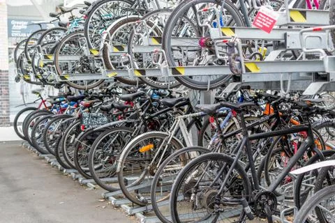 Parked Rows of Commuter Bikes at a Train Station Stock Photos