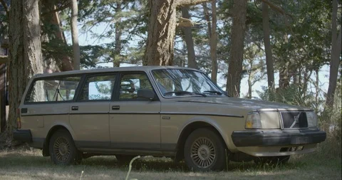 Parked volvo wagon car in the forest on a sunny day Stock Footage