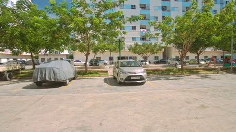 Parking Plot Surrounded by Trees among Houses in City Stock Footage 71487570