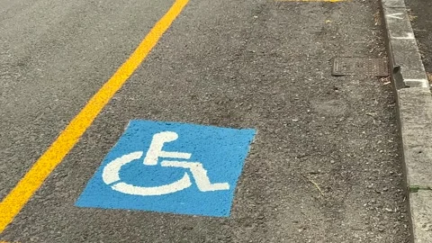 Parking space reserved for disability, marked by the traditional yellow lines Stock Footage 335296800