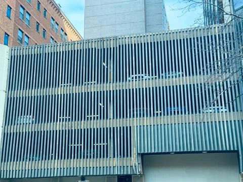 Parking structure shows multiple levels with several cars parked and a buil.. Stock Photos