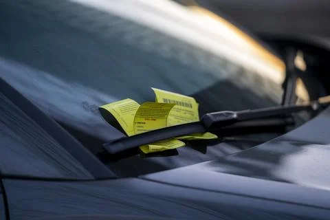 Parking Ticket Secured Under Windshield Wiper on Car Close Up 스톡 사진