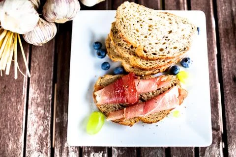 Parma ham on bread on the white plate Fotos de archivo