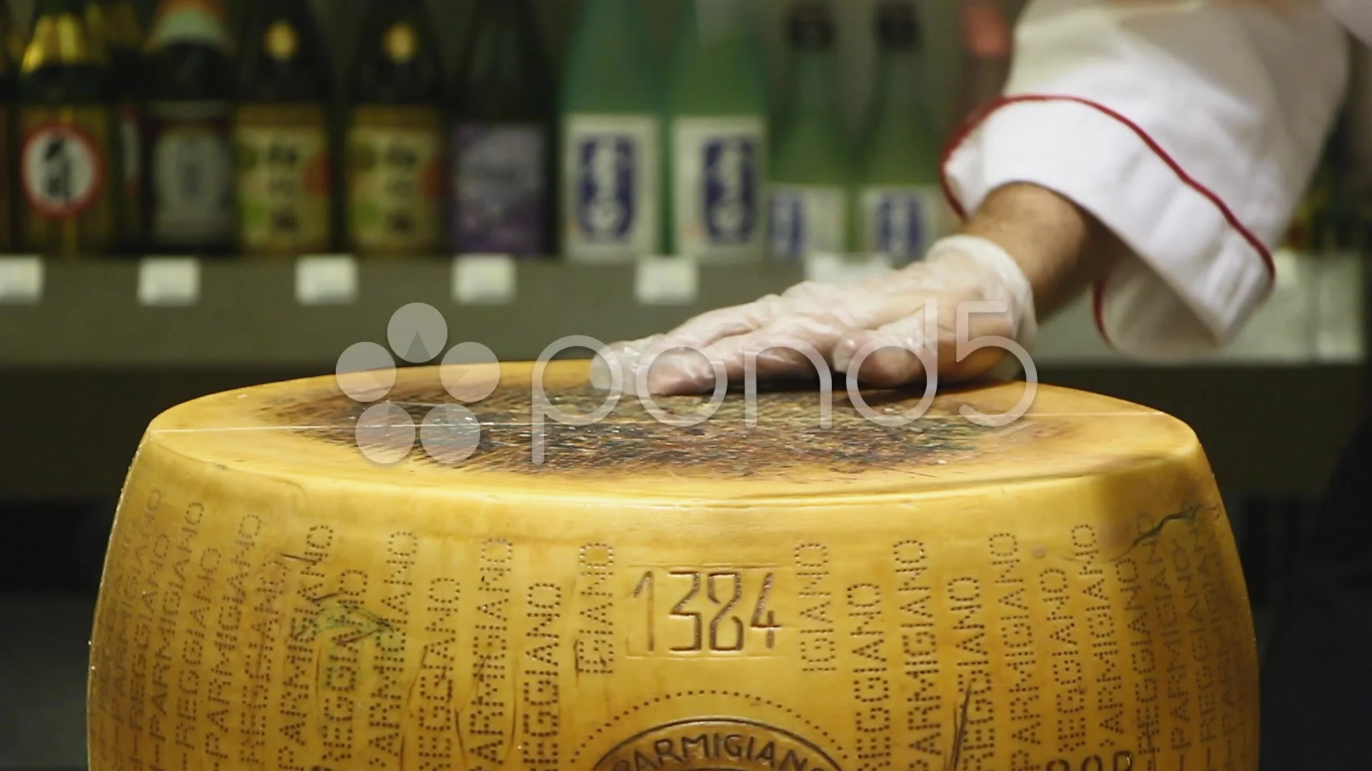 Closeup of a man slicing a Parmigiano Reggiano cheese wheel Stock