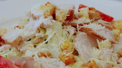 Parmesan cheese cascading over caesar salad, crispy croutons, grilled chicken Stock Footage 327218050