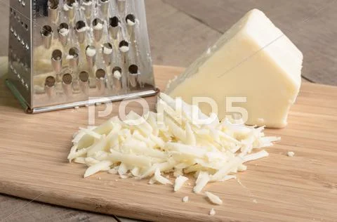 Parmesan cheese grated on a cutting board Stock Photos