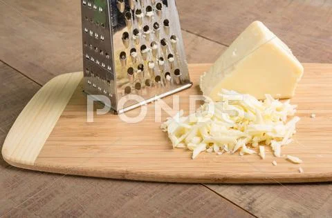 Parmesan cheese grated on a cutting board Stock Photos