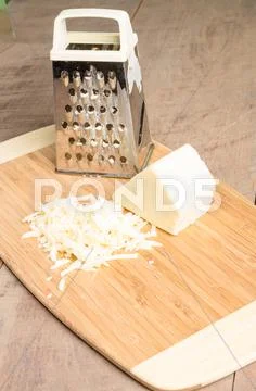 Parmesan cheese grated on a cutting board Stock Photos