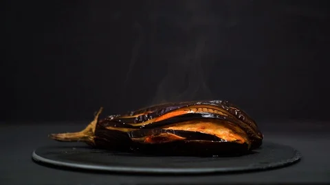 Parmesan falling in slow motion on a steaming roasted eggplant stuffed Stock Footage 129102481