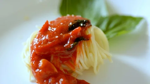 Parmesan is poured over the cooked pasta, for serving in the clientele. Stock Footage 129380508