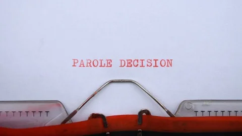 Parole decision - phrase printed on an old typewriter in red letters, close up. Stock Footage 128400349