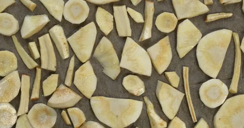 Parsnip slices spread on baking paper on a baking tray. Stock Footage 294242830