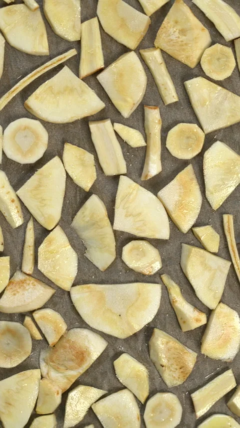 Parsnip slices spread on baking paper on a baking tray. Vertical video. Stock Footage 294242864