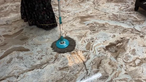 Parson mopping a polished brown and white marble floor with a blue spin mop Stock-Footage 328352204
